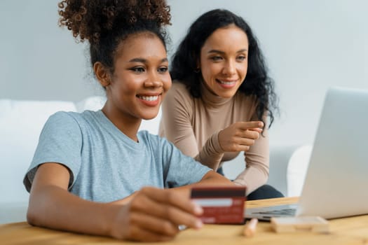 Young happy woman buy product by online shopping at home while ordering items from the internet with credit card online payment system protected by crucial cyber security from online store platform