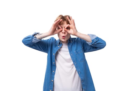 young redhead guy grimacing in blue shirt and white t-shirt.