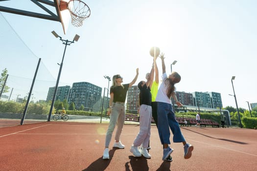 summer holidays, sport and people concept - happy family with ball playing on basketball playground. High quality photo