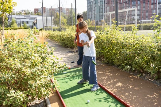 Kids playing golf inside playground artificial grass activity game for children . High quality photo