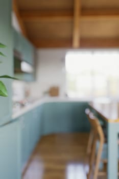 The large green kitchen is out of focus. Green kitchen interior in bokeh. 3D rendering