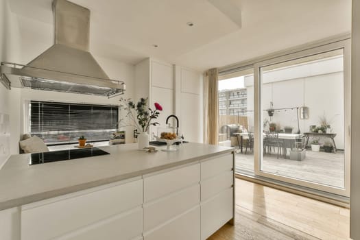 a kitchen with white cabinets and an oven on the counter in front of glass doors that look out onto the patio