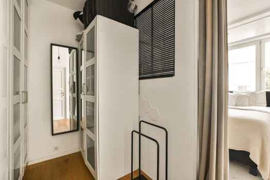 a bedroom with a bed, mirror and closet space in the photo is taken from the doorway to the other room