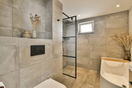 a bathroom with a toilet, shower stall and plant on the wall next to the bathtub in the corner