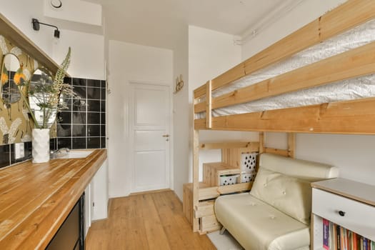 a living room with bunks on the walls and wood flooring in front of the couch is next to the bed