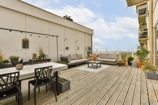 an outdoor living area with wood flooring and patio furniture on a sunny day in the photo is taken from outside