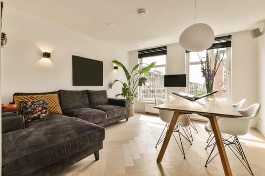 a living room with a couch, table and television on the wall in front of the sofa is dark grey