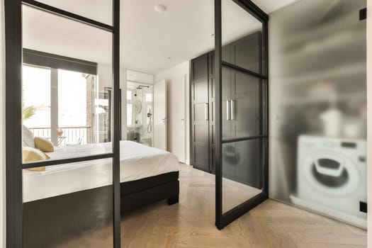 a bedroom with a bed, mirror and toilet in the room behind it is an open door that leads to a bathroom