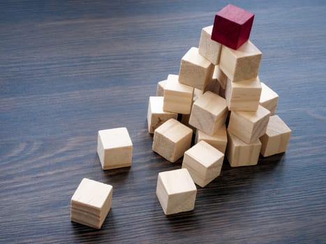 A pyramid of cubes with red on top as the leader. Success in business and career, be the first.