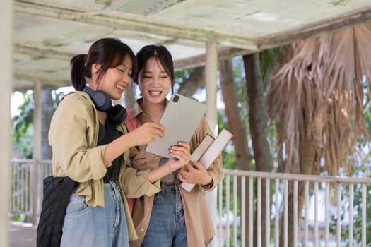 Two college student female friends smile ready for class at the university campus.