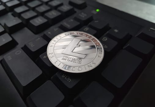 Coin crypto currency Litecoin lies on the keyboard background theme gold exchange pyramid for money due to rise or fall exchange rate closeup