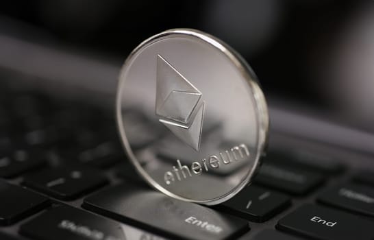 Coin crypto currency ethereum lies on the keyboard background theme of the silver. Exchange pyramid for money due to the rise or fall of the exchange rate.