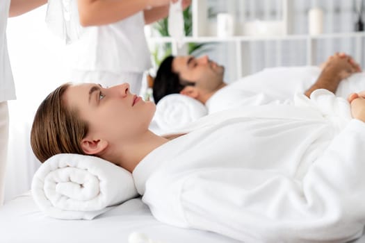 Serene modern daylight ambiance of spa salon, couple customer indulges in rejuvenating with facial skincare mask. Facial skin treatment and beauty cosmetology procedure for face. Quiescent