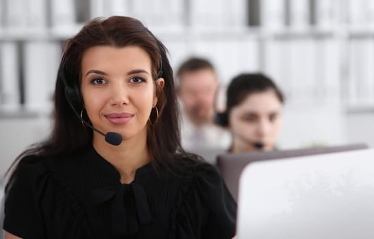 Three call centre service operators at work. Portrait of smiling pretty brunette woman at workplace employment effective mediation negotiation participation solve problem real time aid job concept