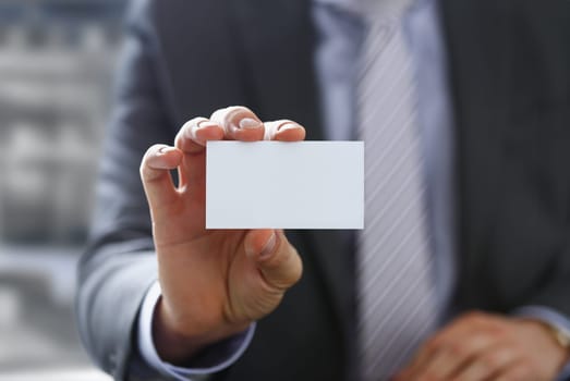Male arm in suit give blank calling card to visitor closeup. White collar colleagues company name exchange job interview sale clerk id, executive or ceo finance support formal identity concept