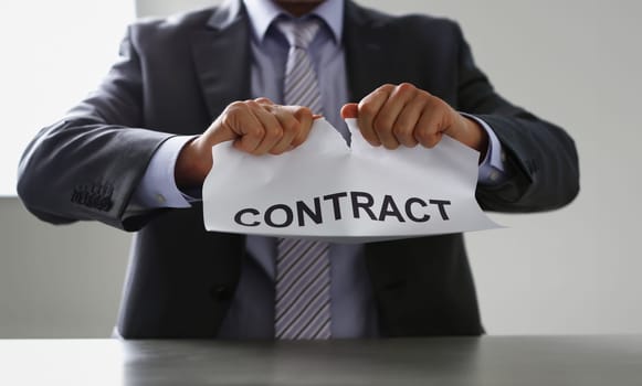 White collar worker in suit and tie tear contract closeup. Get jobless arm form rip job loss customer offer human resources staff reduction service failure legal trouble attitude concept