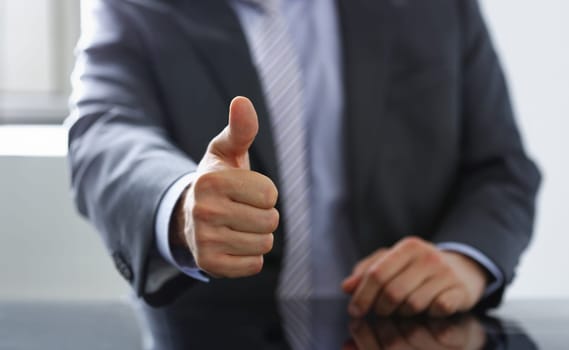 Male hand showing ok or confirm sign with thumb up during conference closeup. High level and quality product serious offer mediation solution happy client creative adviser participation concept