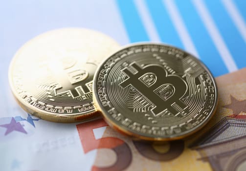 The coin of crypto currency bitcoin against background euro banknote subject gold. Exchange pyramid for money in connection with the growth or fall exchange rate closeup.