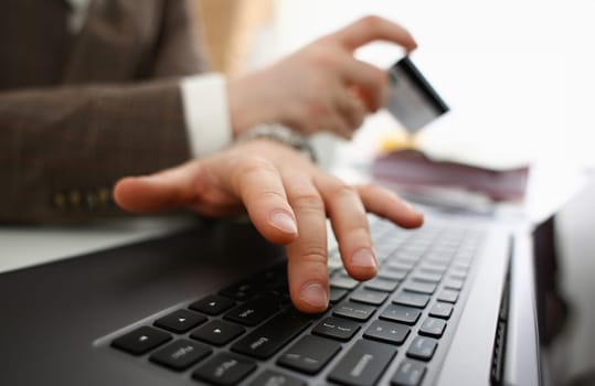 Male arms hold credit card press buttons making transfer closeup. Anti-fraud financial security when entering client discount program number or filling personal credential password login to account