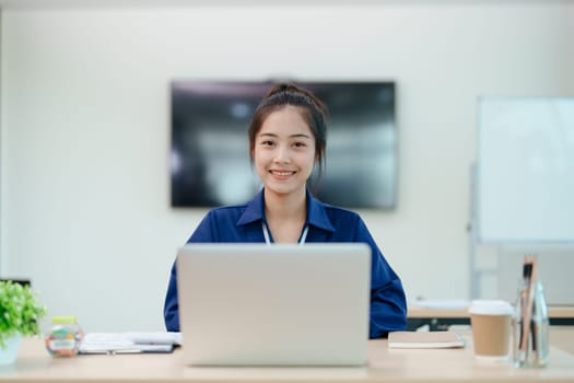 Young asian businesswoman manager, lawyer or company employee holding accounting bookkeeping documents checking financial data or marketing report working in office with laptop. Paperwork management.