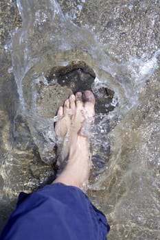 splashing water tourist feet on beach shore summer vacation metaphor
