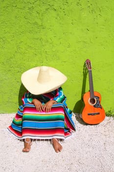 Nap lazy typical mexican sombrero man sitting on green wall