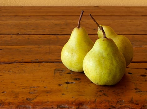 three mature pears on old wood table