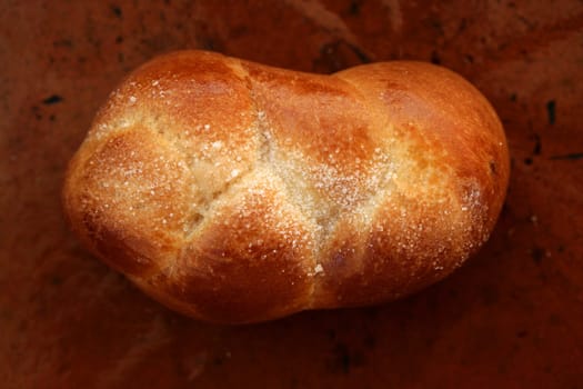 One brioche pastrie close up, brown clay background, macro bakery