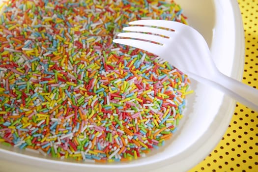 Colorful little sweet candy plate with fork, children delice
