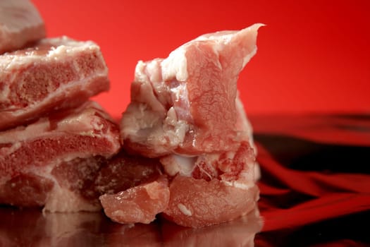 Pig, pork raw meat pieces over red background