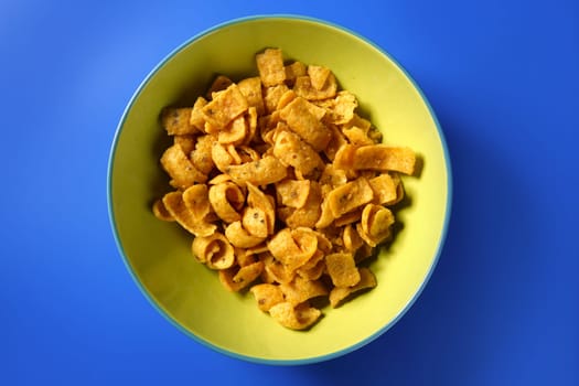 Fried corn golden snack in plate over blue background