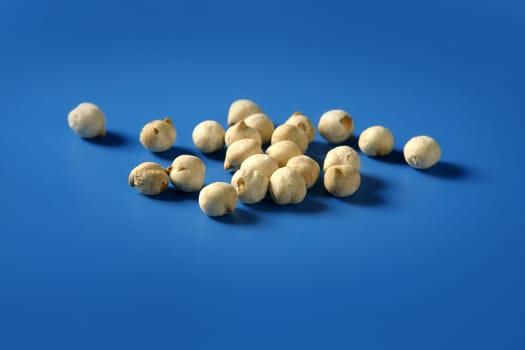 Chickpeas still spread over vivid blue background