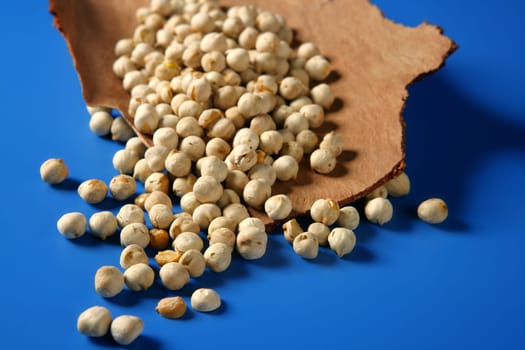 Chickpeas still spread over vivid blue background