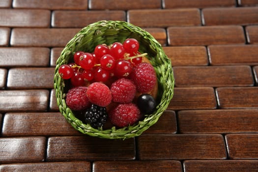 Mixed forest berries dessert  in a green little basket
