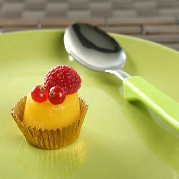 Delicious redcurrant, raspberry and sweet egg cake with green spoon
