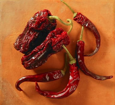 Red hot chili peppers over orange clay background