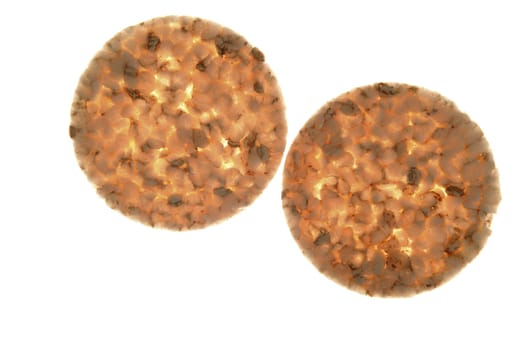 Two transparent round corn slices salted biscuits on white