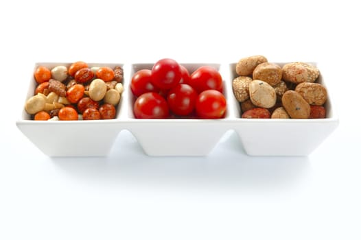 Long triple bowl with varied japanese snacks and tomatoes