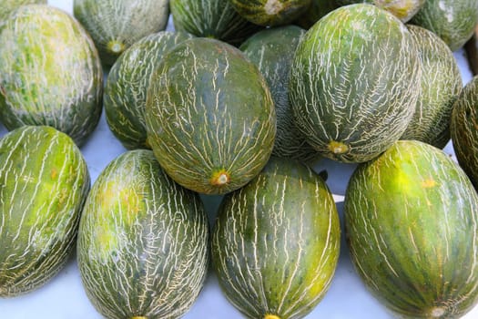 Piel de Sapo Santa Claus melon stacked rows in fruit market