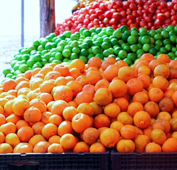 tangerine oranges lemon and tomatoes in market place