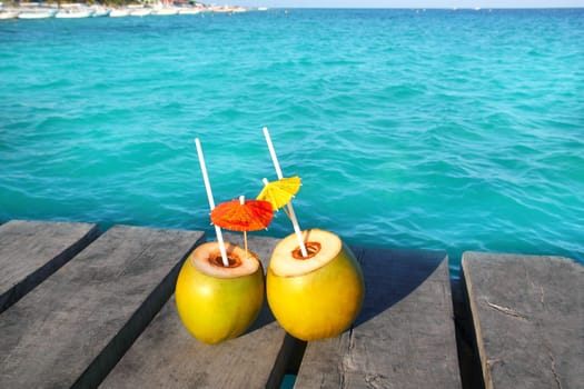 coconut coktails in caribbean on wood pier turquoise sea