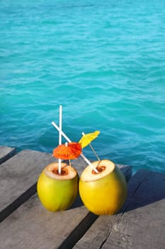 coconut coktails in caribbean on wood pier and turquoise sea