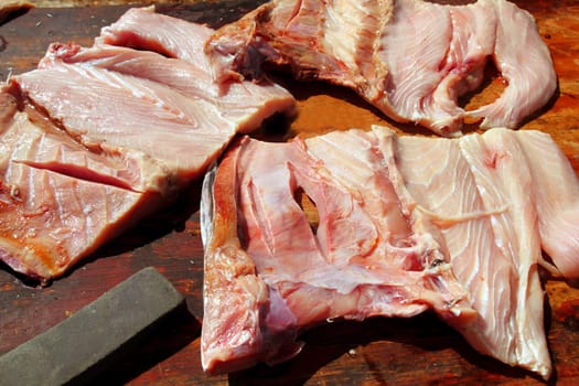 amberjack fish three fillets over wooden table