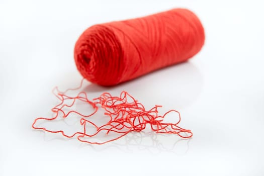 Red thread spool isolated over white studio background