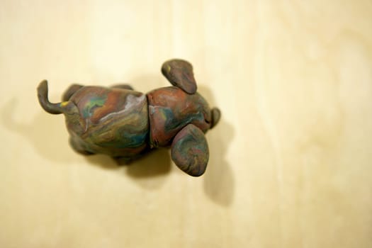 Plasticine brown dog over maple wood background