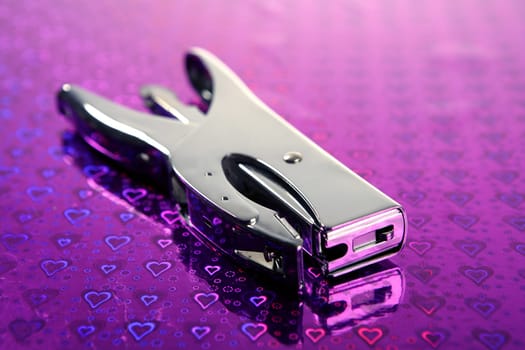 professional office stuff, chorme stapler over purple heart background