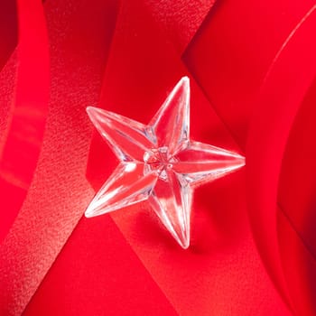 christmas glass star on red ribbon background