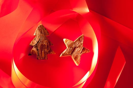 Christmas tree and star of tree bark on red background and ribbon
