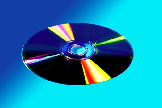 CD DVD disk with colorful reflexion over vivid blue background