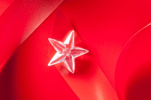 christmas glass star on red ribbon background
